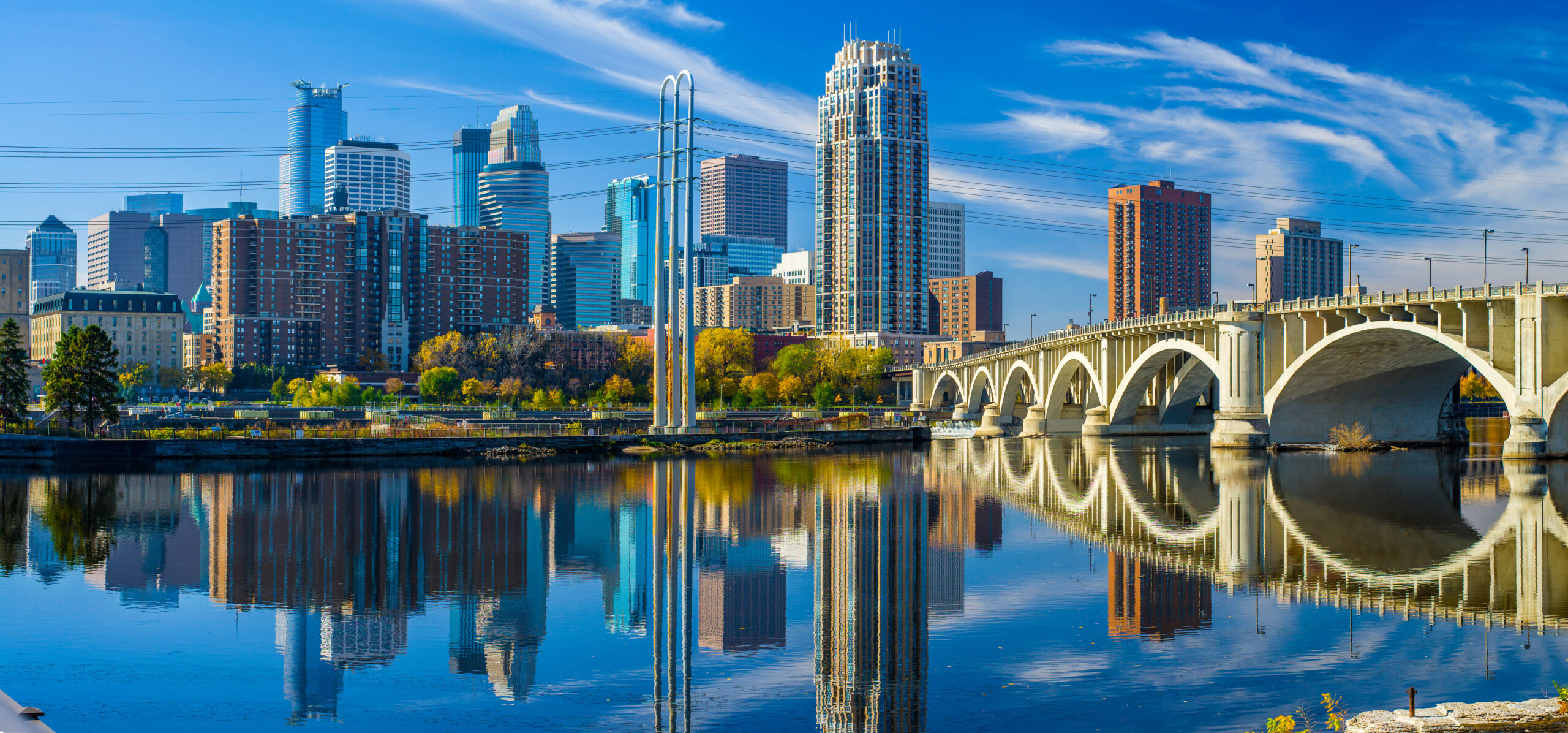 minneapolis skyline, 3rd avenue bridge, autumn the 3rd avenue bridge crosses over the mississippi river toward the minneapolis skyline, autumn