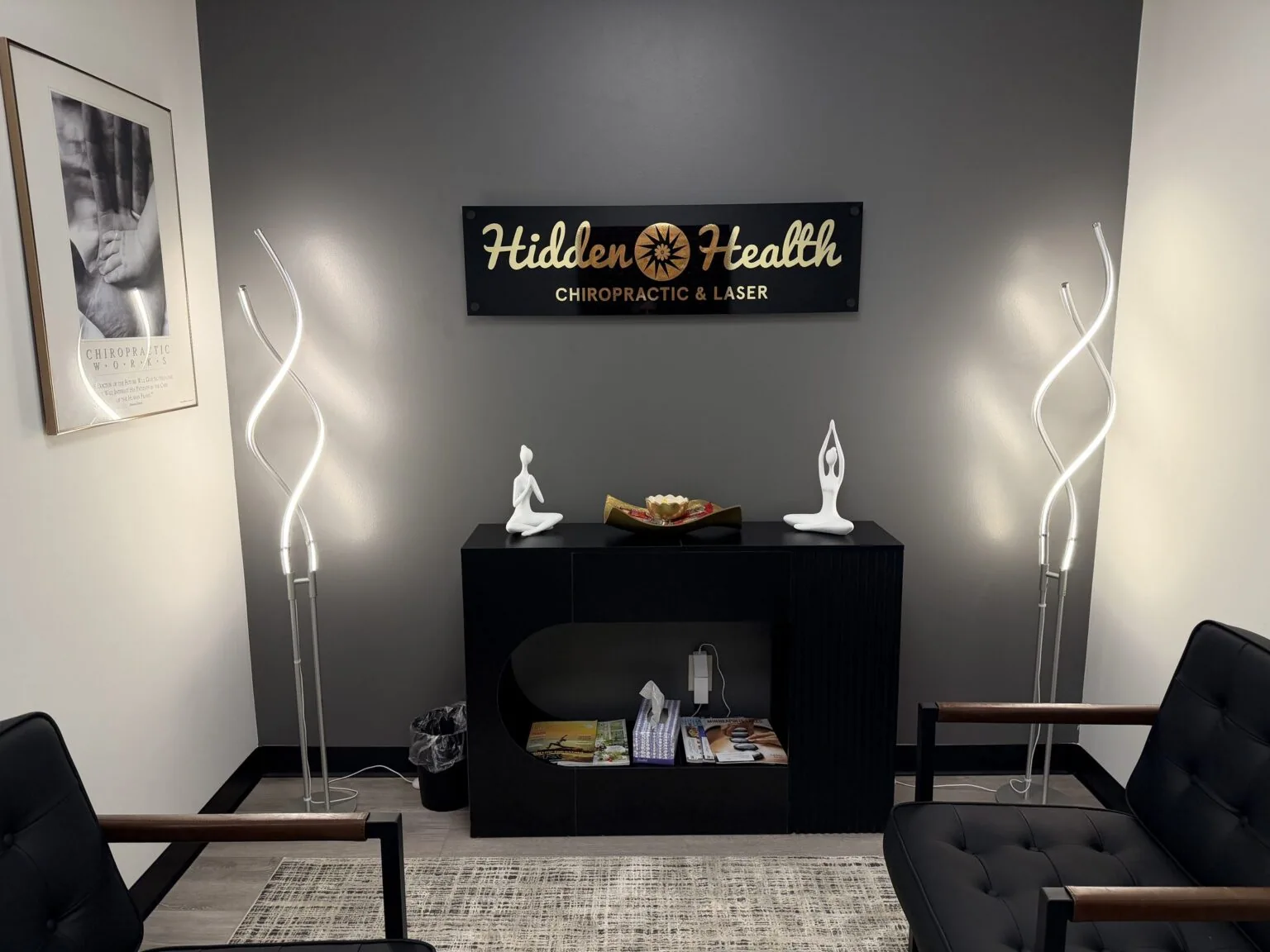 The Hidden Health reception area in Edina, with the gold sunburst logo sign, soft lamps and leather chairs