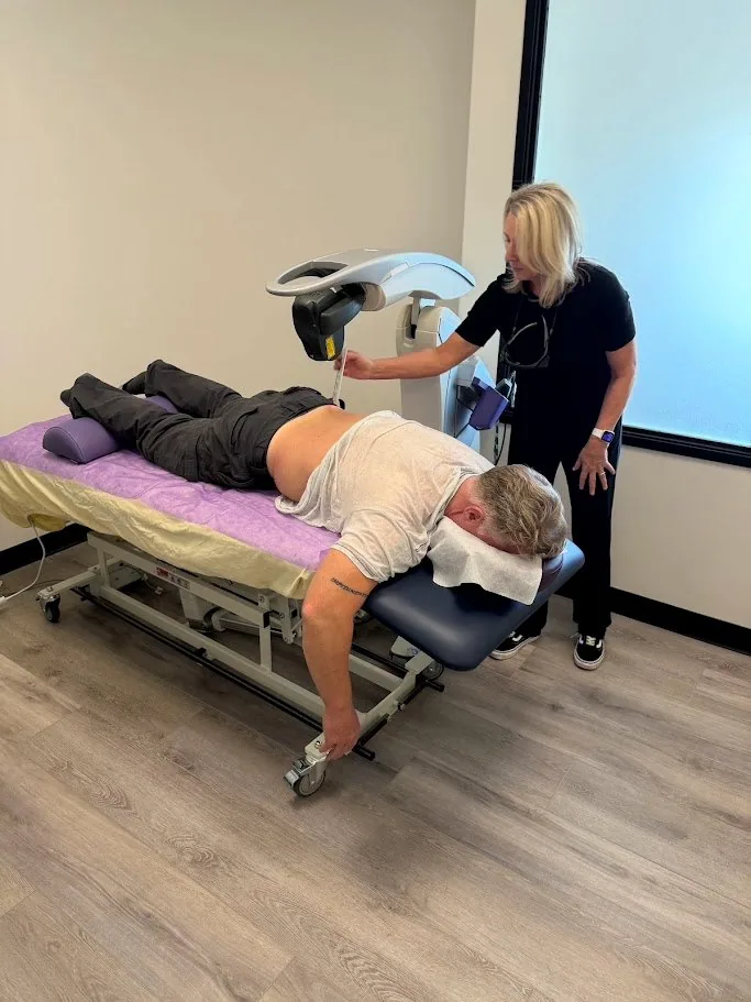 Dr. Shona positioning the MLS M7 laser over a patient’s back